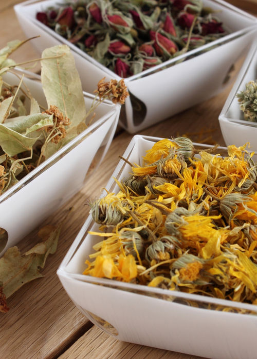 Fiori essiccati in ciotole: calendula, tiglio e rosa per i rimedi fitoterapici