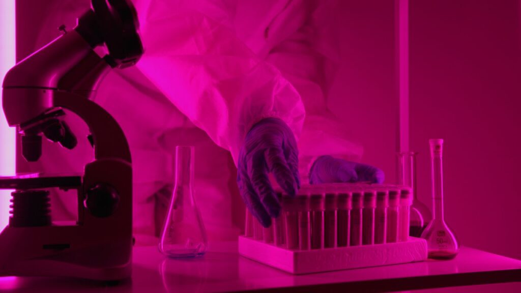Ricercatore che analizza provette al microscopio