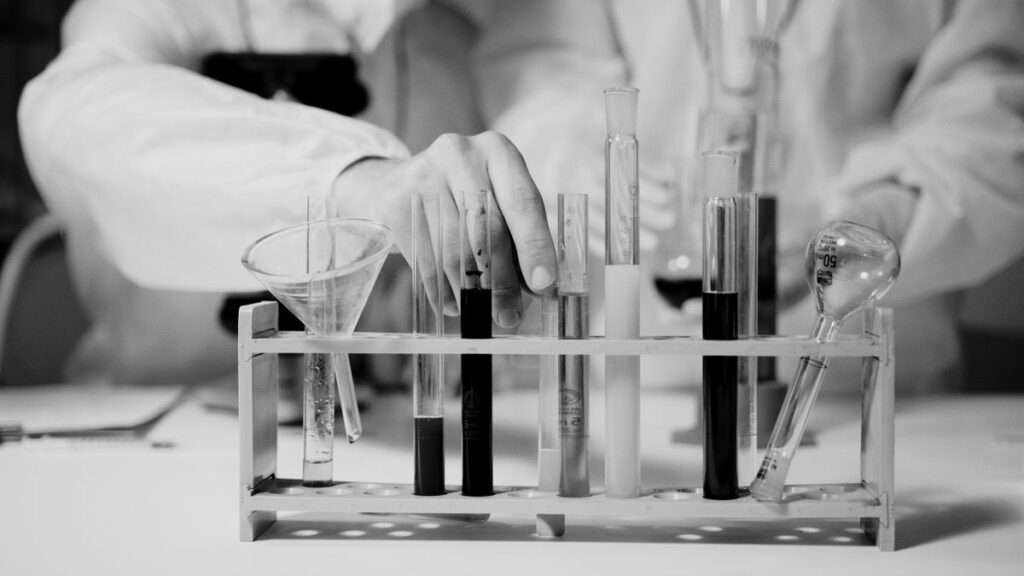 Mano di uno scienziato con provette in laboratorio